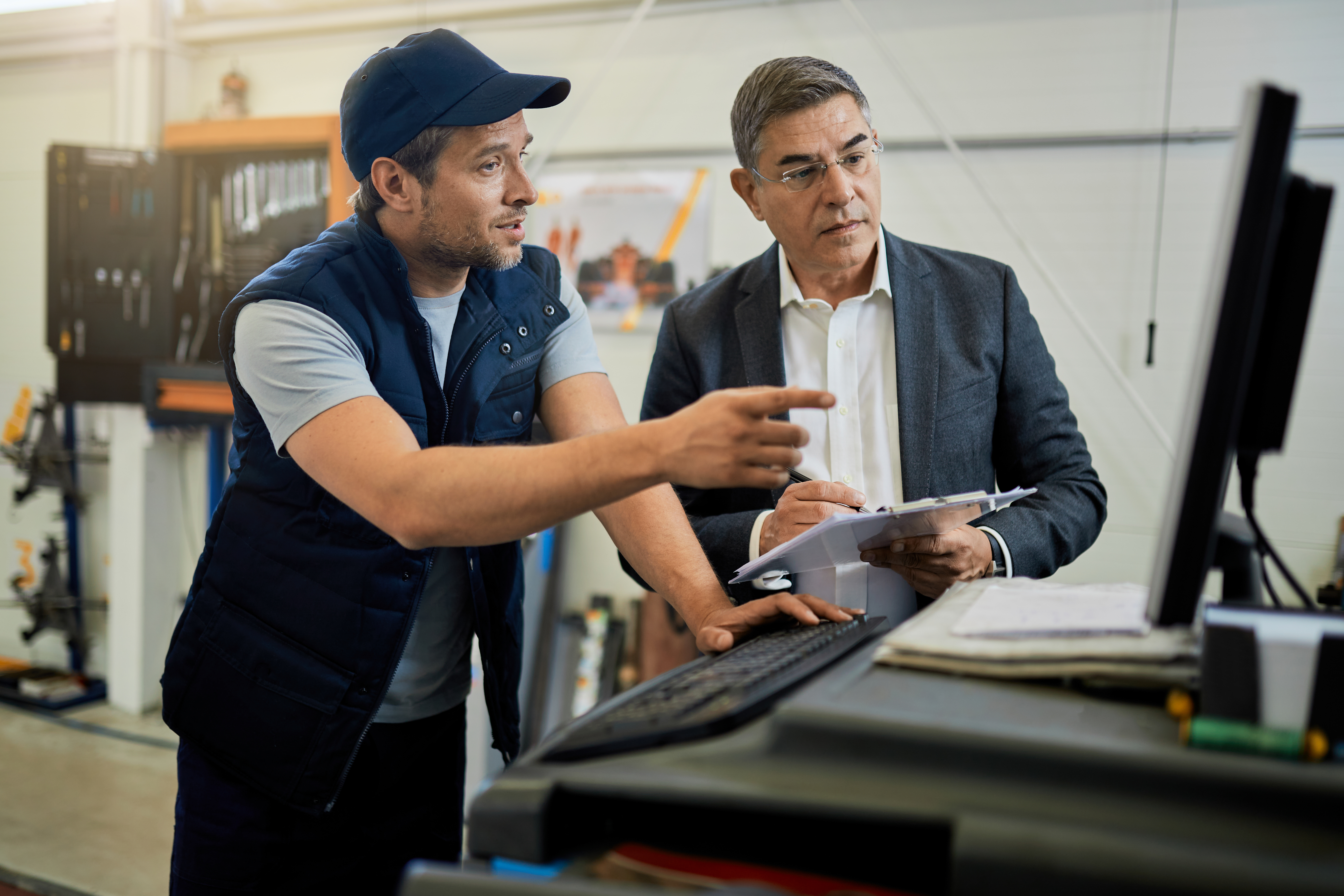 Ingeniero técnico de Systemtronicx SAS explicando informe de auditoría y mantenimiento preventivo a un administrador corporativo en Bogotá.